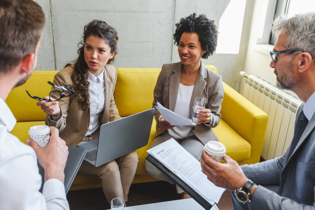 Group of male and female business leaders and team members meeting to discuss technology upgrades